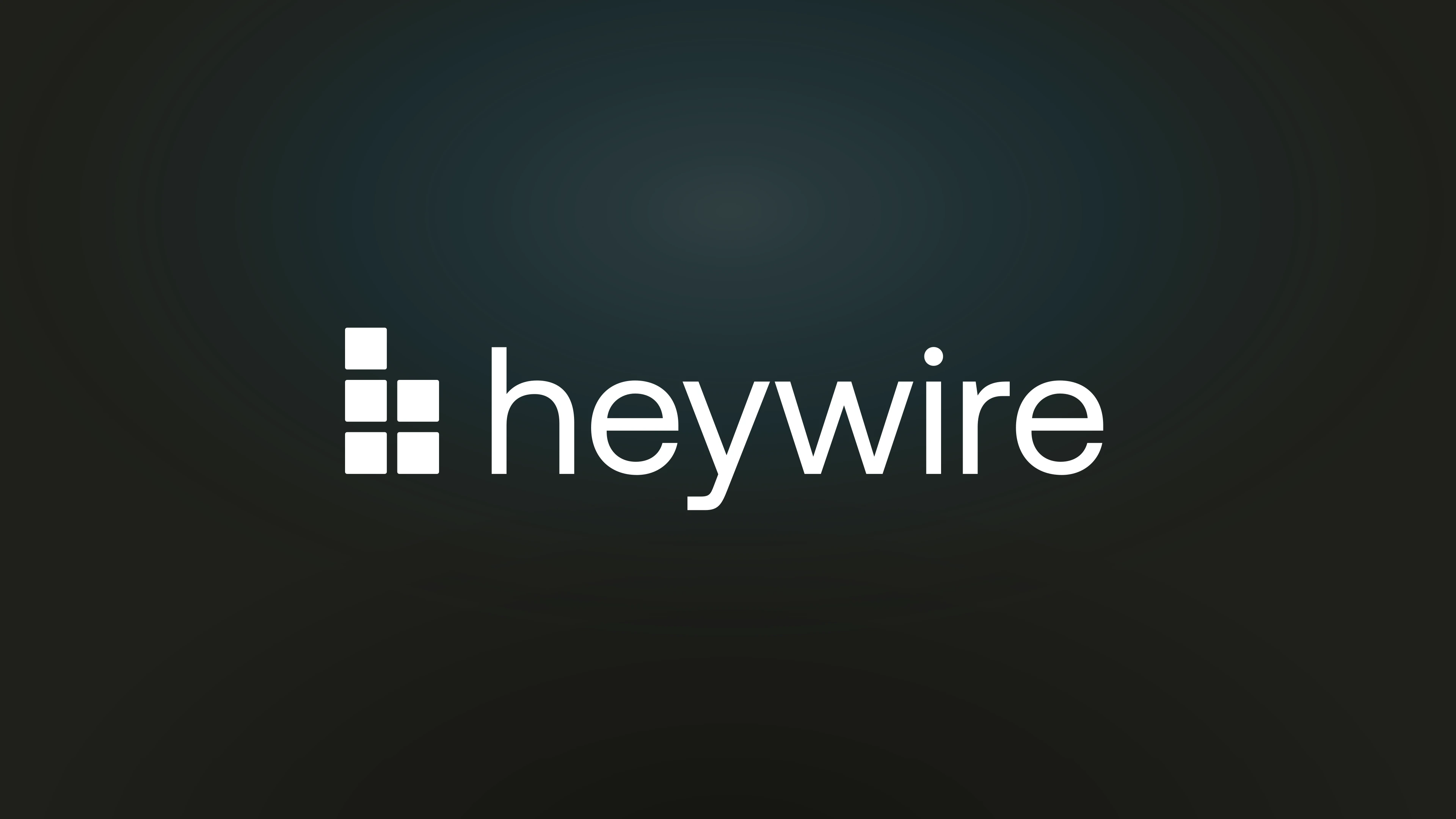 The Heywire brand plate: the stacked-blocks mark and the heywire wordmark on the brand's charcoal with a soft blue glow.